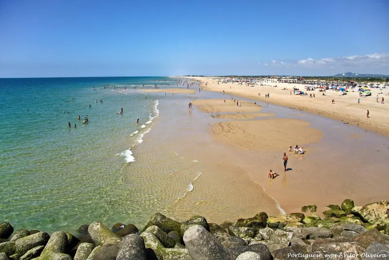 Long sandy beach and shallow turquoise water on Ilha de Tavira on a sunny day