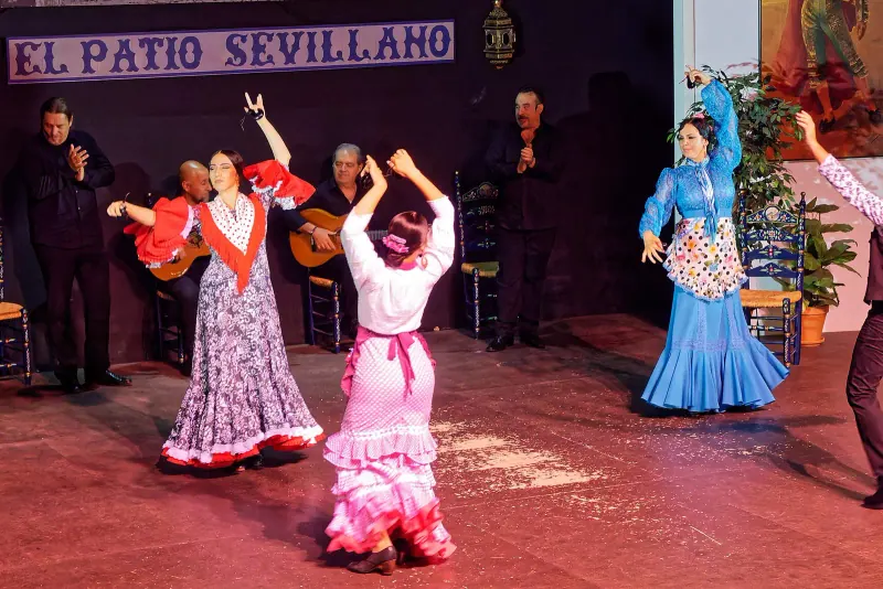 Flamenco dancers in ruffled dresses on stage