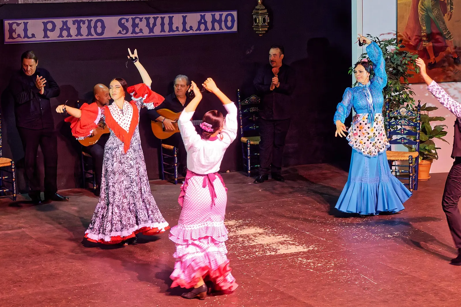 Flamenco dancers in ruffled dresses on stage