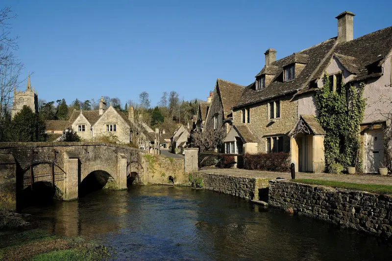 Stone cottages and the packhorse bridge over the river in Castle Combe