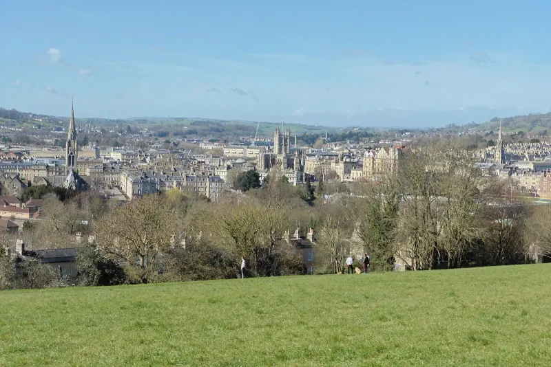The city of Bath spread below a hillside field
