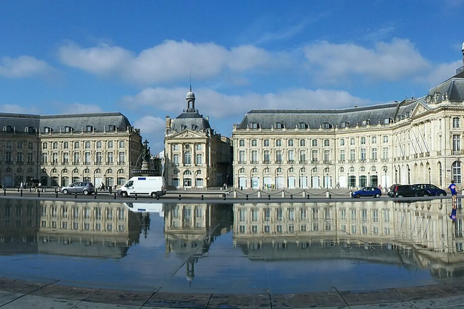The Miroir d'eau reflecting Place de la Bourse under a blue sky