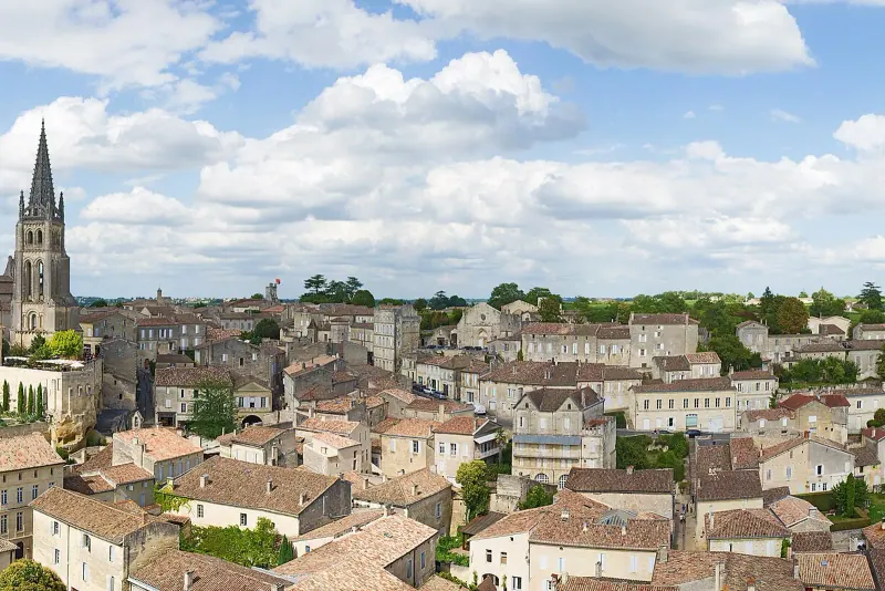 Rooftops and the church spire of Saint-Emilion surrounded by vineyards