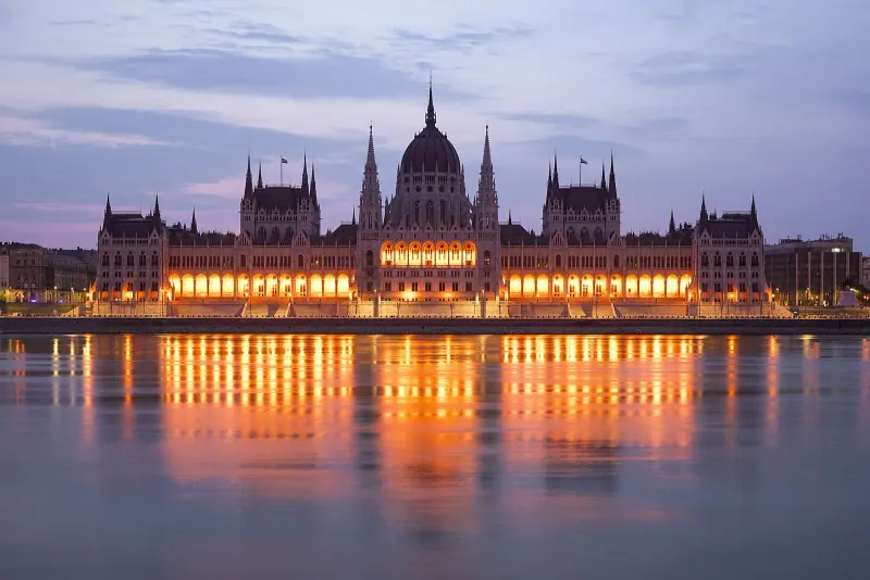 The Hungarian Parliament lit across the Danube at dusk