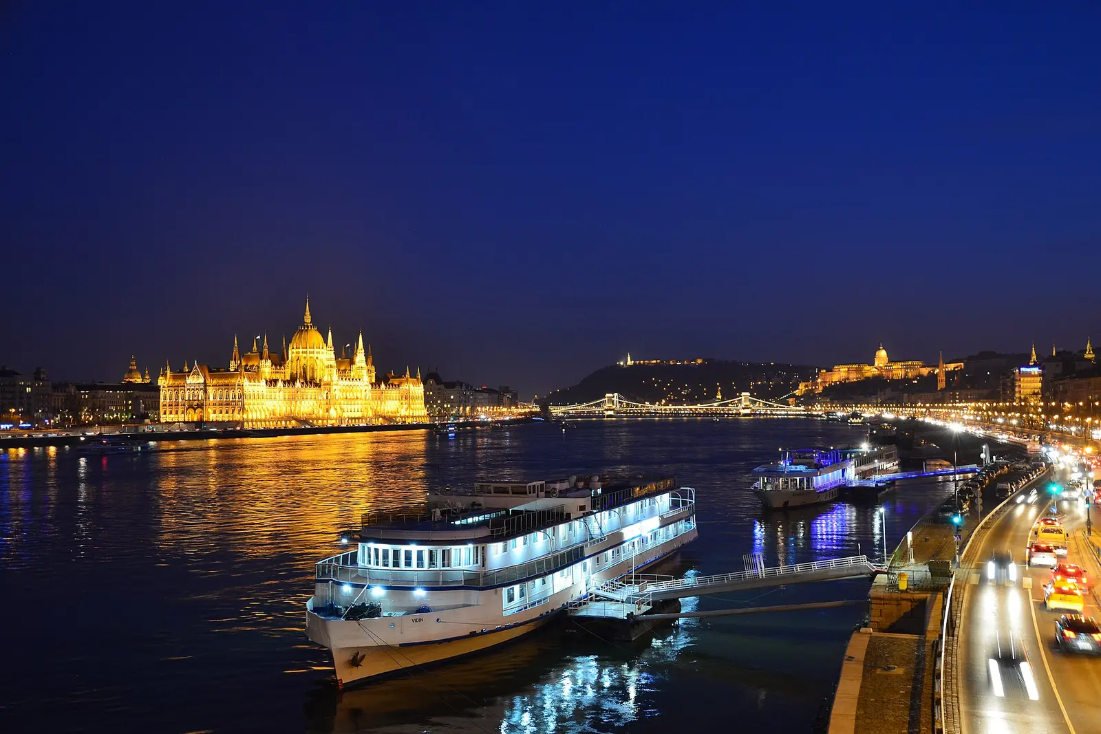 A lit river boat on the Danube below Buda Castle
