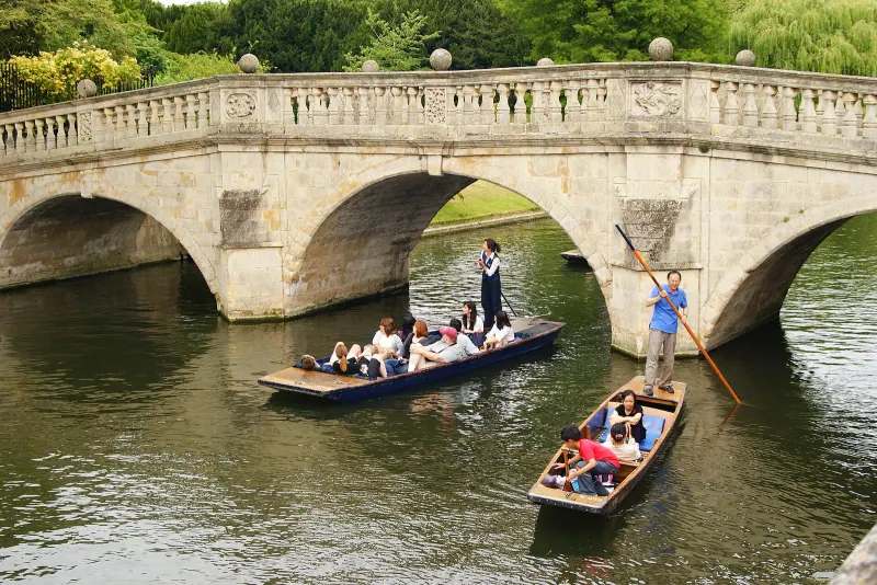 Punters passing under a bridge on the Backs