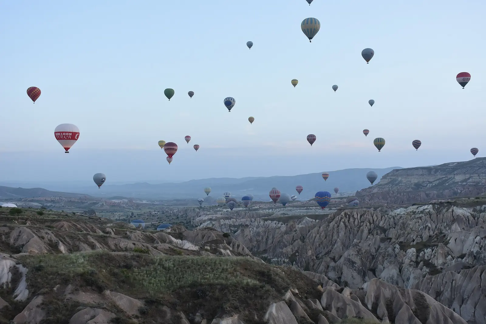 Hot-air balloons rising over Cappadocia at sunrise