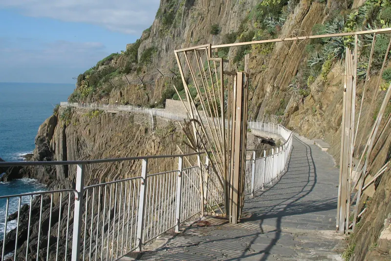 Railed footpath of the Via dell'Amore cut into a steep cliff above the sea