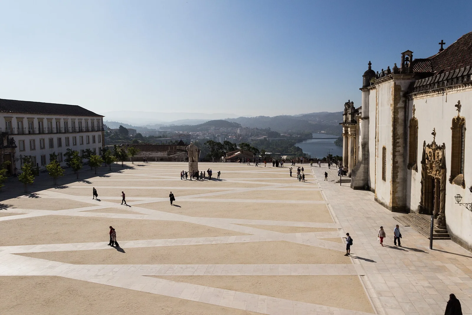 The Paço das Escolas courtyard at Coimbra University with the Joanina chapel facade and the Mondego river beyond