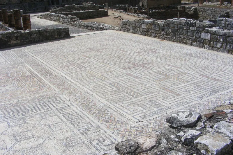 A large geometric mosaic floor still in place among the excavated walls of Conimbriga