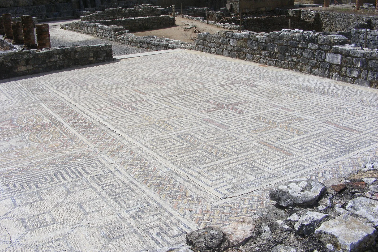 A large geometric mosaic floor still in place among the excavated walls of Conimbriga