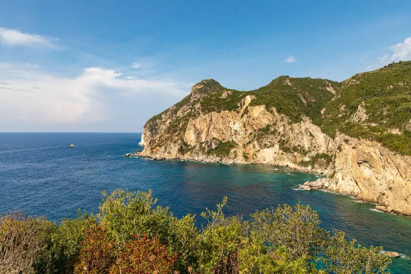 Aerial of a green headland over a turquoise bay