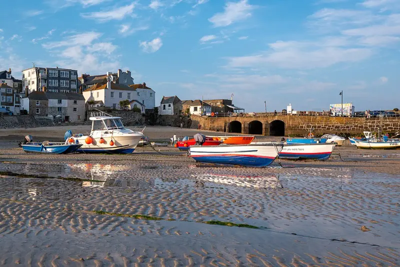 Fishing boats resting on the sand at low tide in St Ives harbor, Cornwall