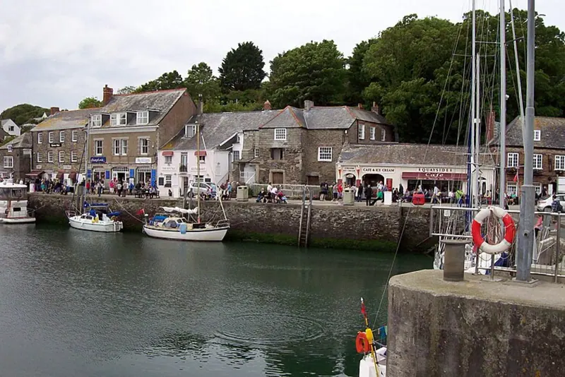Padstow harbor with moored sailboats and waterfront houses along the quay