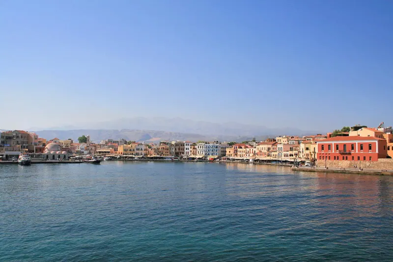 Chania's Venetian harbour curving toward its lighthouse, Crete