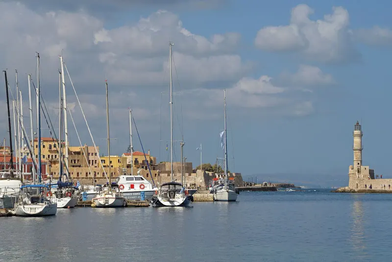 Chania lighthouse across the harbour promenade, Crete
