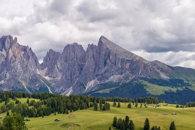 The Sassolungo and Sella peaks above green alpine meadows