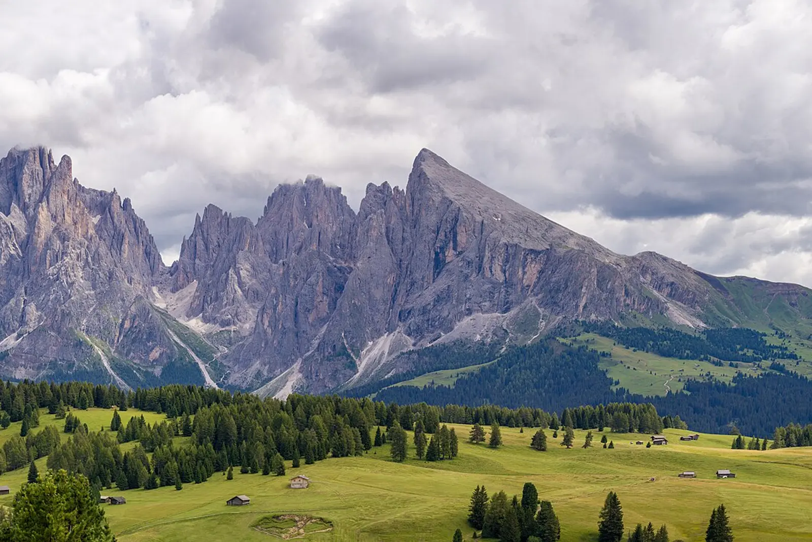 The Sassolungo and Sella peaks above green alpine meadows