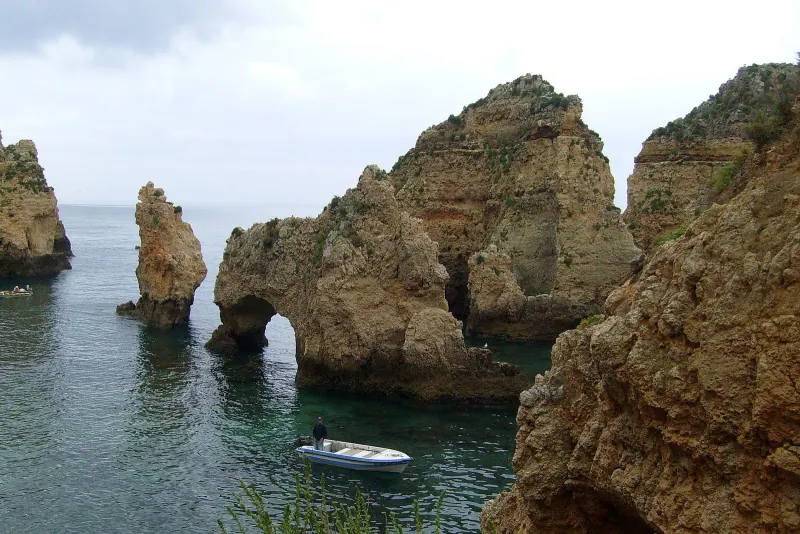 A boat threading the sea stacks at Ponta da Piedade