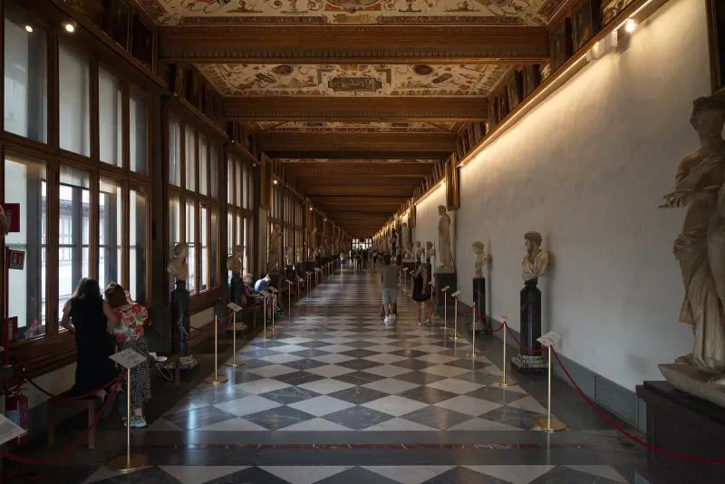 A long corridor of the Uffizi Gallery lined with statues