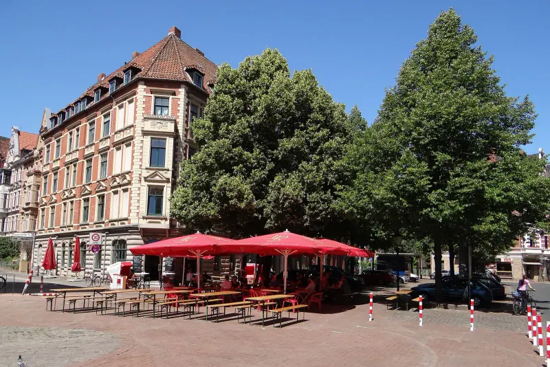 Market square tables under red umbrellas
