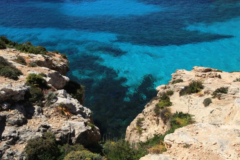 The turquoise water of the Blue Lagoon on Comino seen from the rocks above
