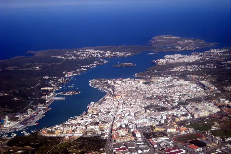 Mahon harbour and the old town rising above the water in Menorca