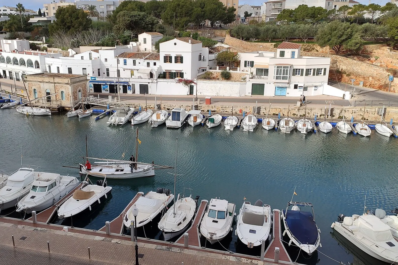 Yachts moored along Ciutadella's narrow harbour inlet in Menorca
