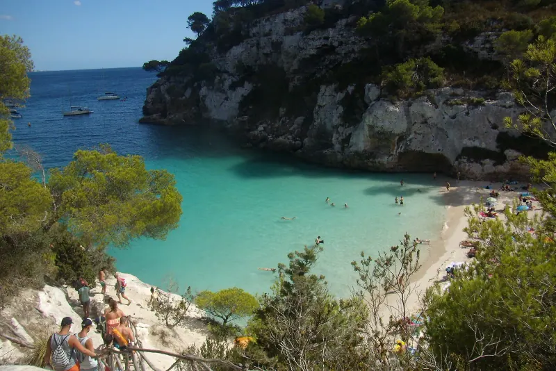Turquoise water filling the tiny cove of Cala Macarelleta