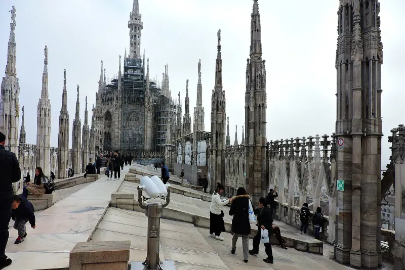 Visitors walking among the spires on the roof terraces of Milan Cathedral