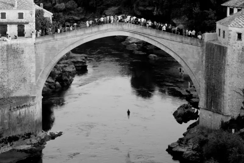 A diver mid-air beneath the Stari Most in Mostar