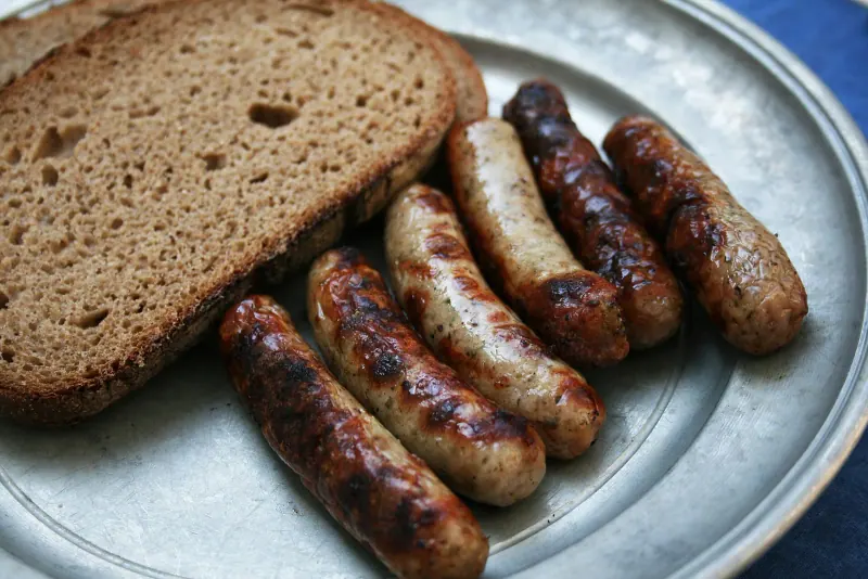 Grilled Nuremberg bratwurst sausages on a pewter plate