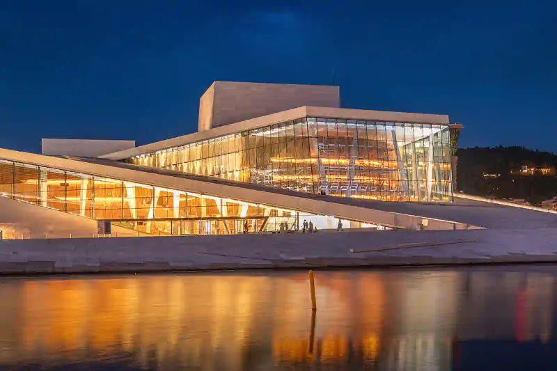 The Oslo Opera House at night, its sloped marble roof lit from within