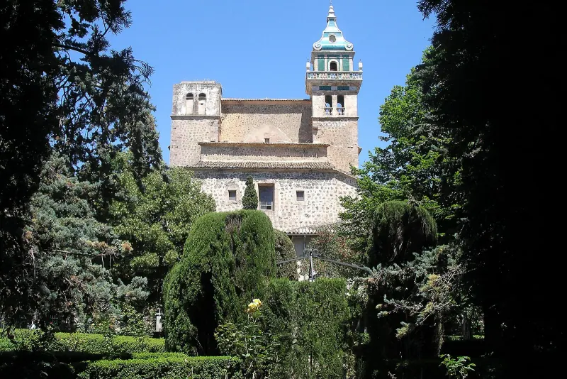 The Valldemossa charterhouse through the trees