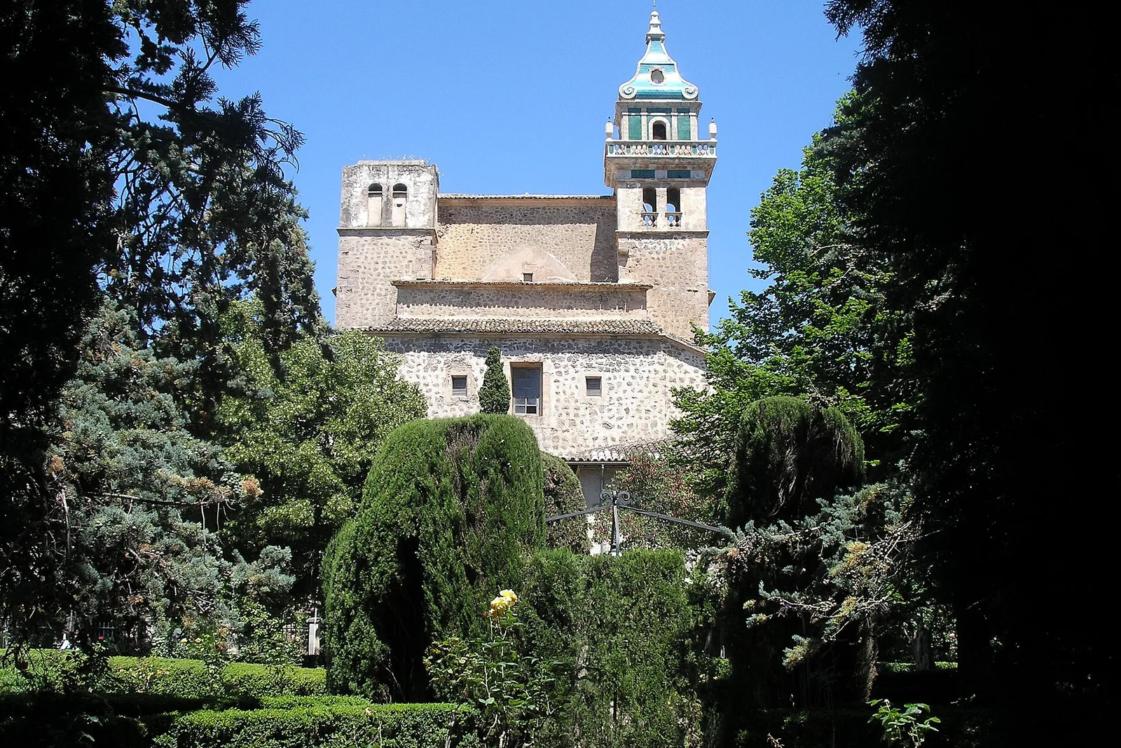 The Valldemossa charterhouse through the trees