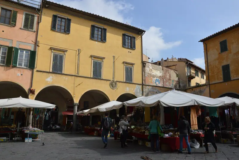 Market stalls under arcades on Piazza delle Vettovaglie in Pisa