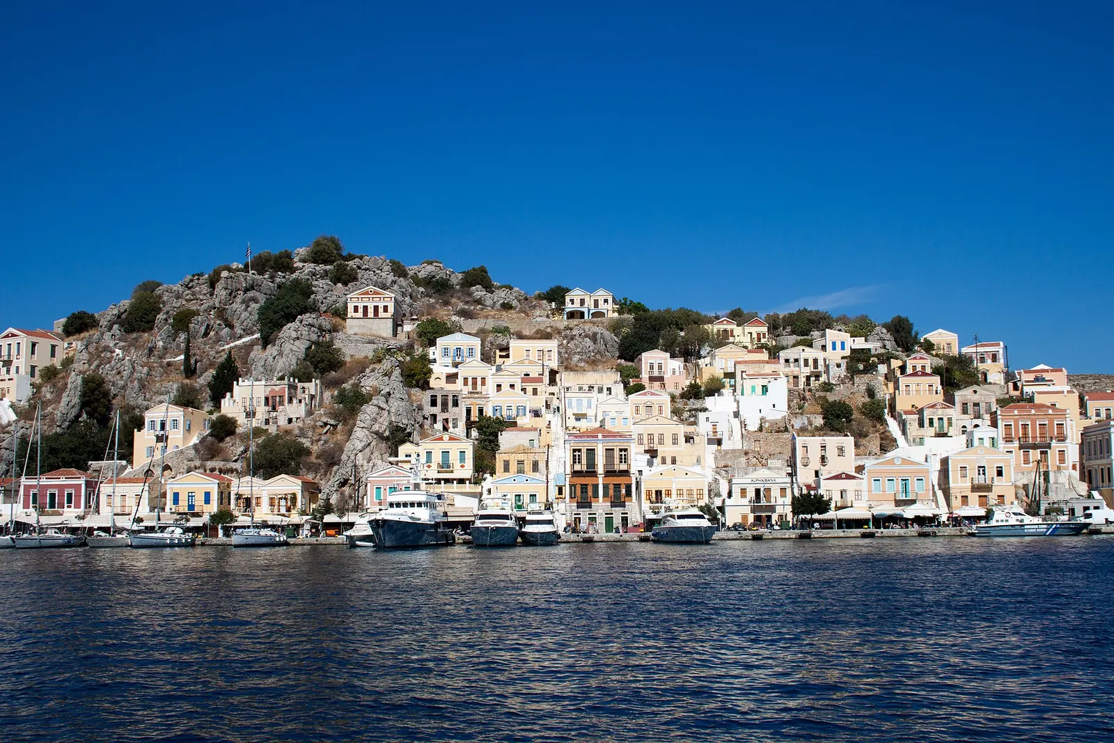 Neoclassical houses rising behind Symi's harbour