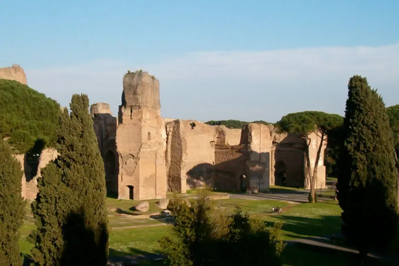 Brick ruins of the Baths of Caracalla among pines and cypresses