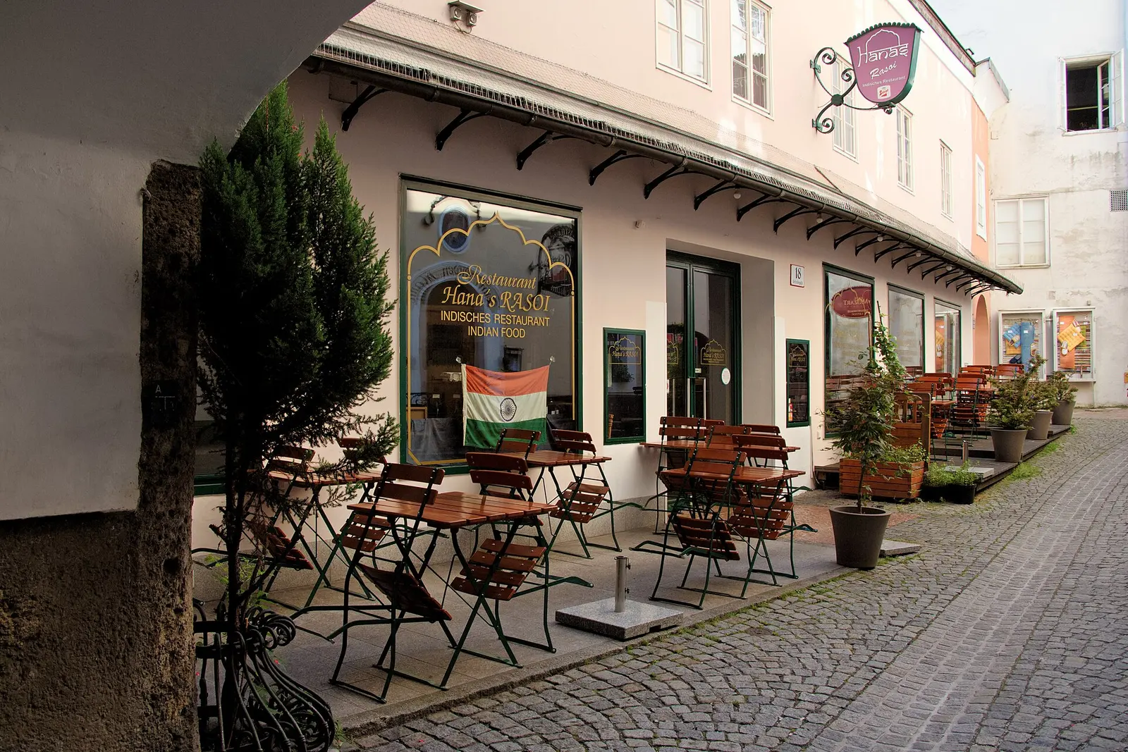Café tables on a cobbled lane in Salzburg's old town