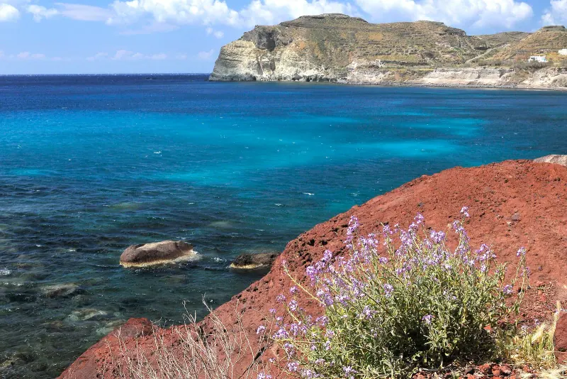 Red cliffs falling into turquoise water at Red Beach, Santorini