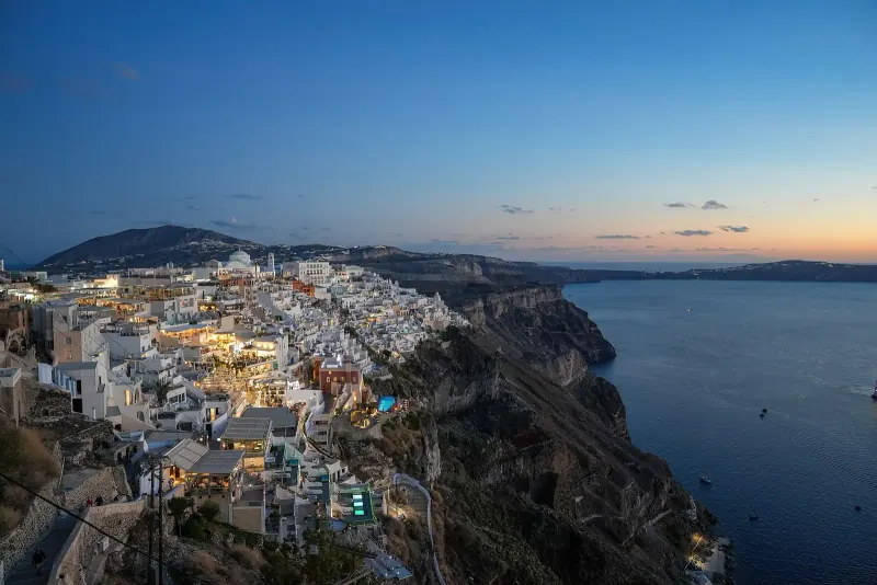 Oia's white houses glowing at dusk over the caldera