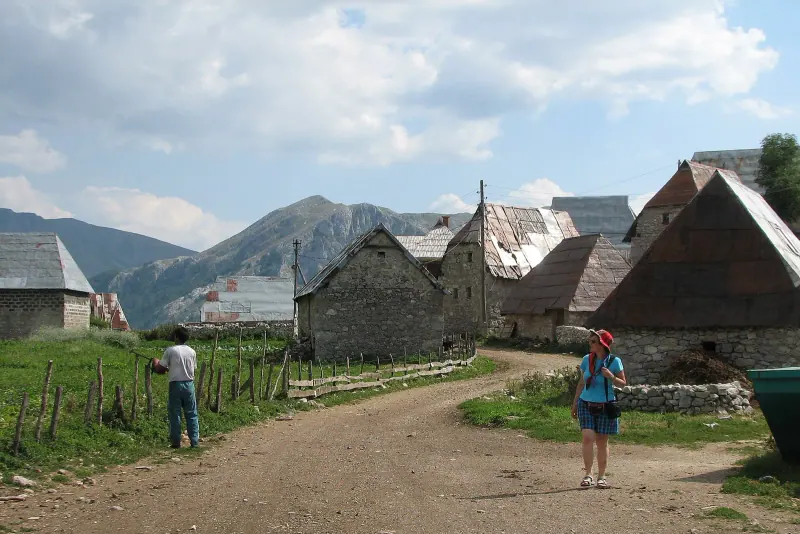 Lukomir village seen from the trail above the Rakitnica canyon, stone houses on the green slope