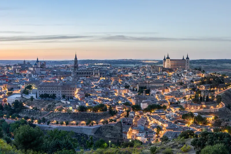 Toledo's walled skyline and Alcazar above the Tagus gorge at dusk, seen from across the river