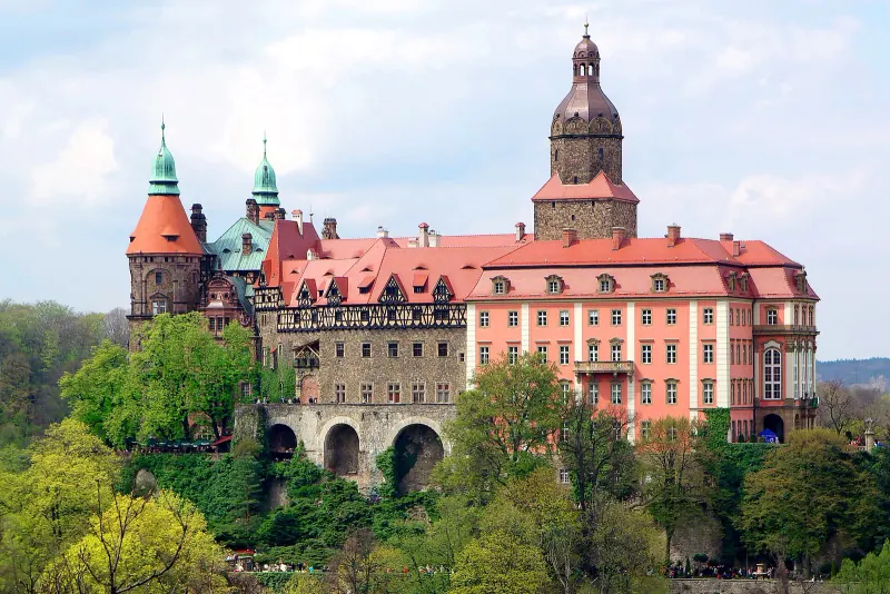 Ksiaz Castle pink facade on its wooded ridge above Walbrzych