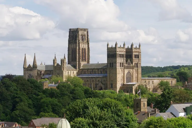 Durham Cathedral rising above trees on its riverbank peninsula